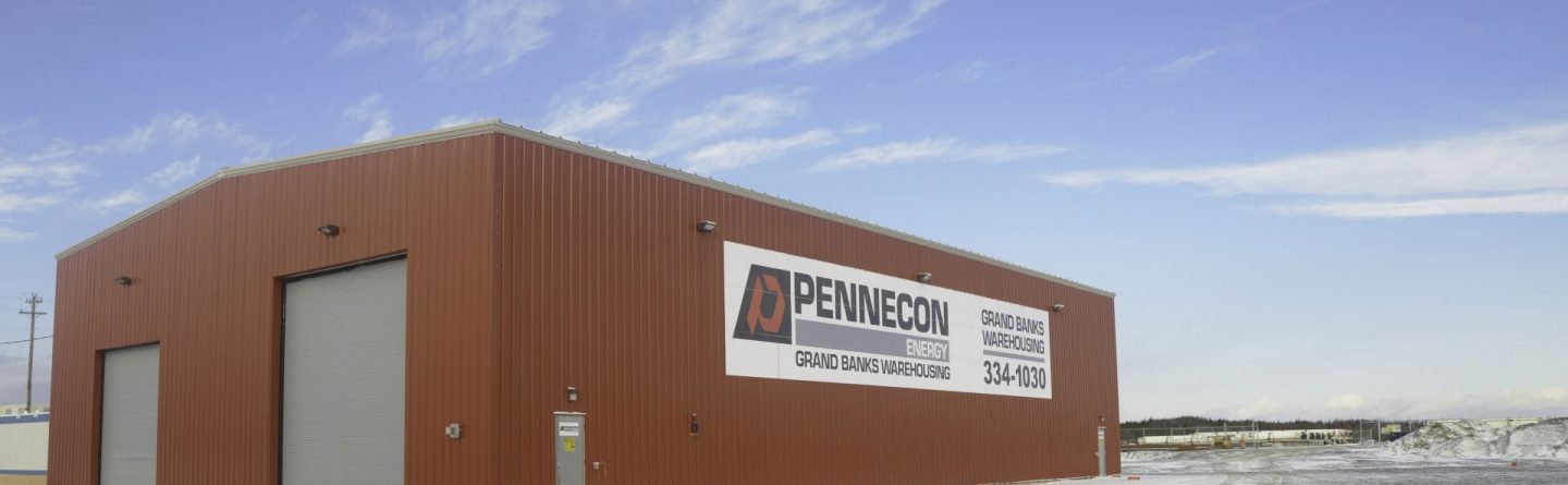A large red metal warehouse with a sign reading "PENNECON GRAND GANG WAREHOUSE" stands in a snowy lot under a partly cloudy sky.